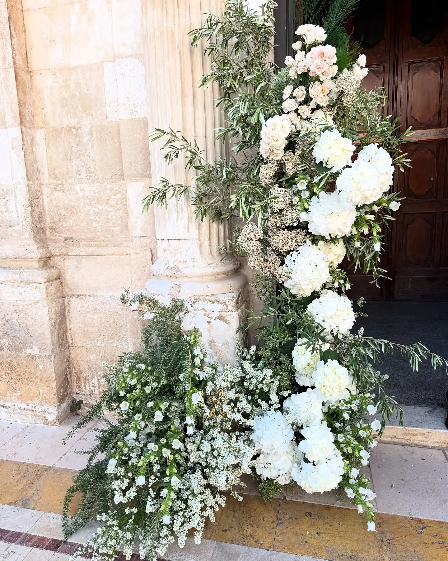 Aranjament floral alb la intrarea unei biserici