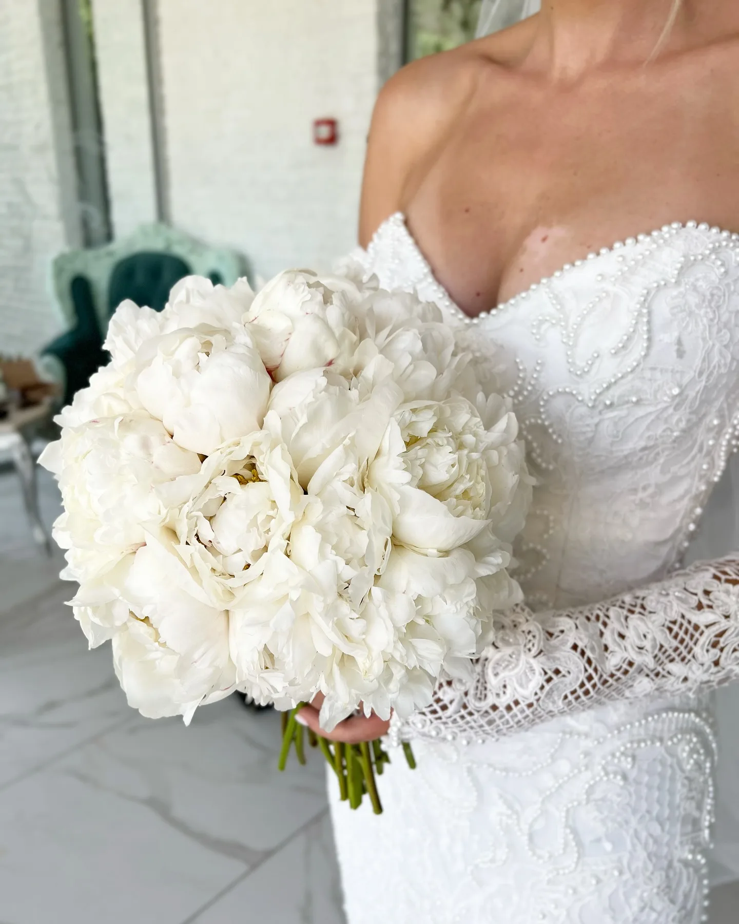 Buchet de bujori albi pe rochie de mireasă