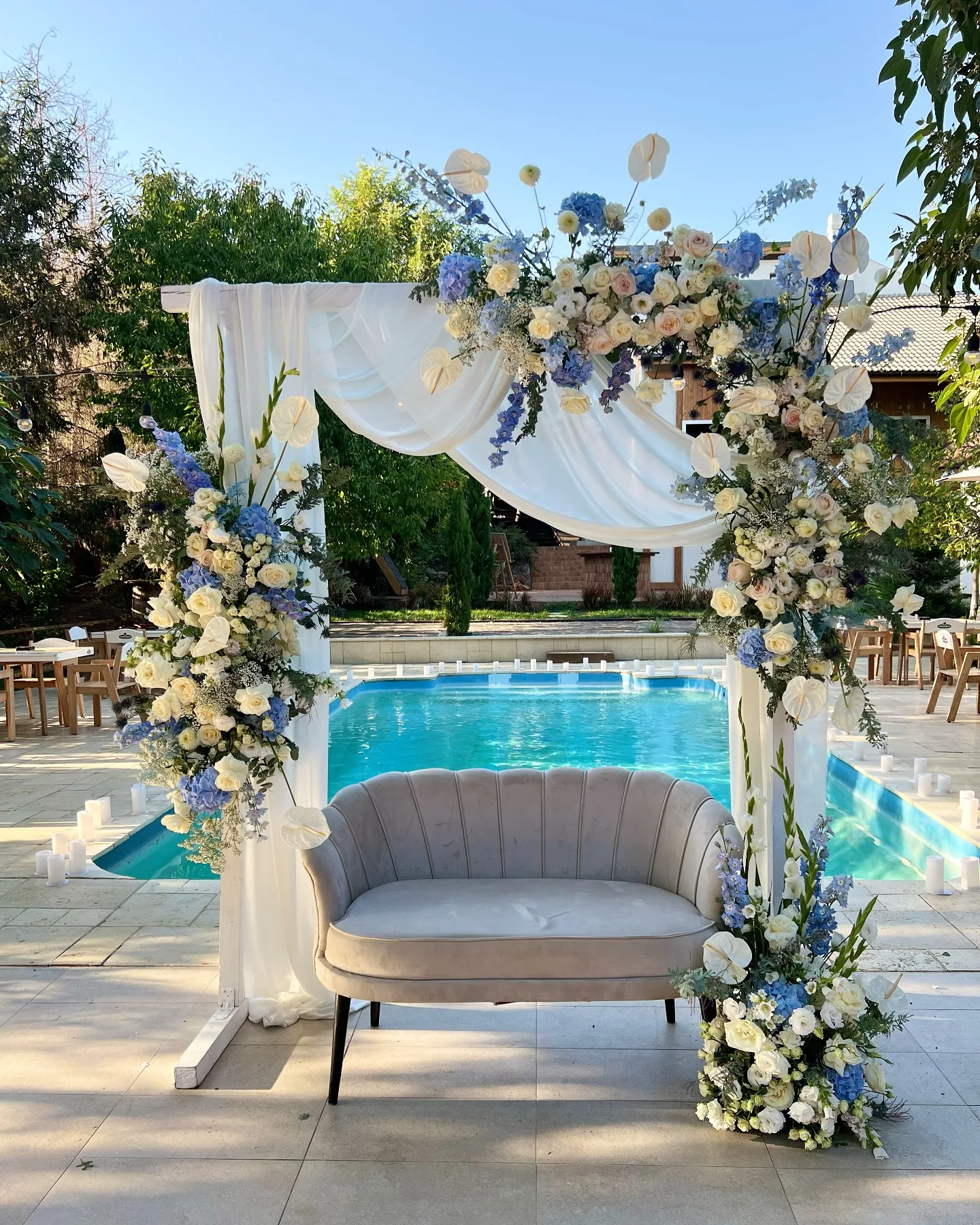 Arcadă cu flori albastre lângă piscină